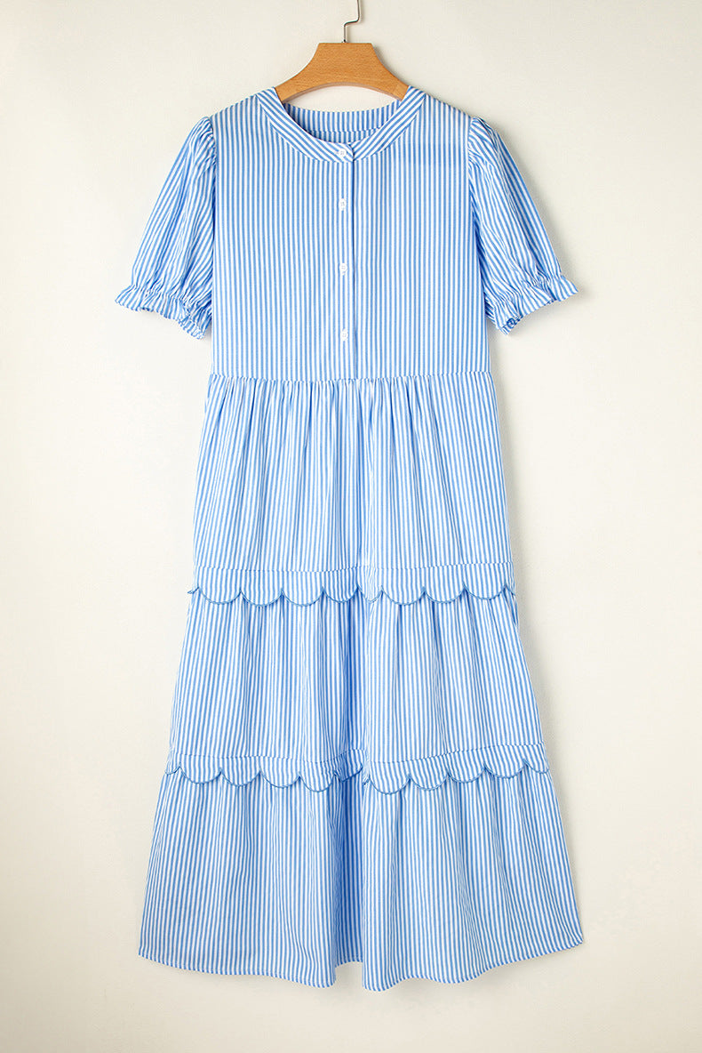 Blue and white striped dress on a hanger against a beige background