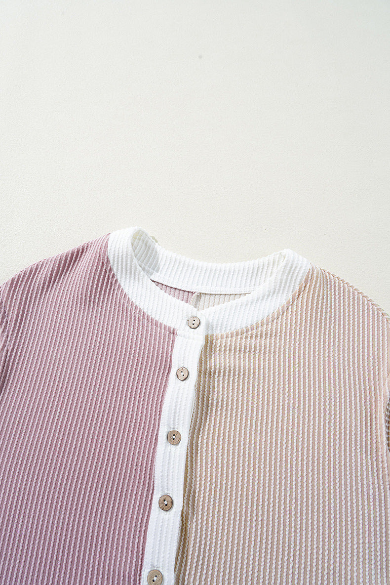 Close-up of a ribbed sweater with a white collar and buttons on a light gray background