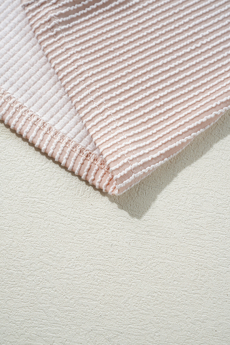 Close-up of a pink textured fabric on a light gray background