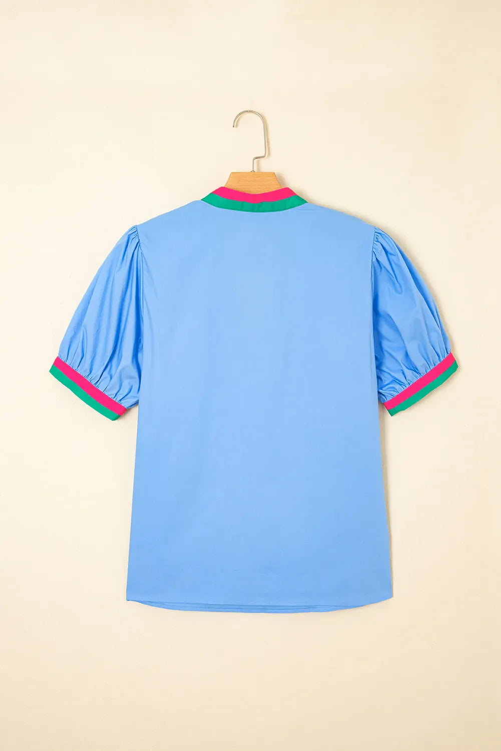 Light blue shirt with colorful trim on a beige background