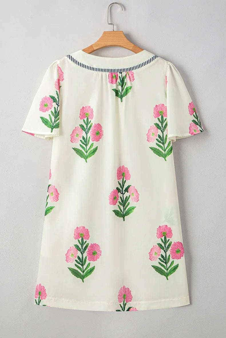 White dress with pink floral patterns on a light gray background