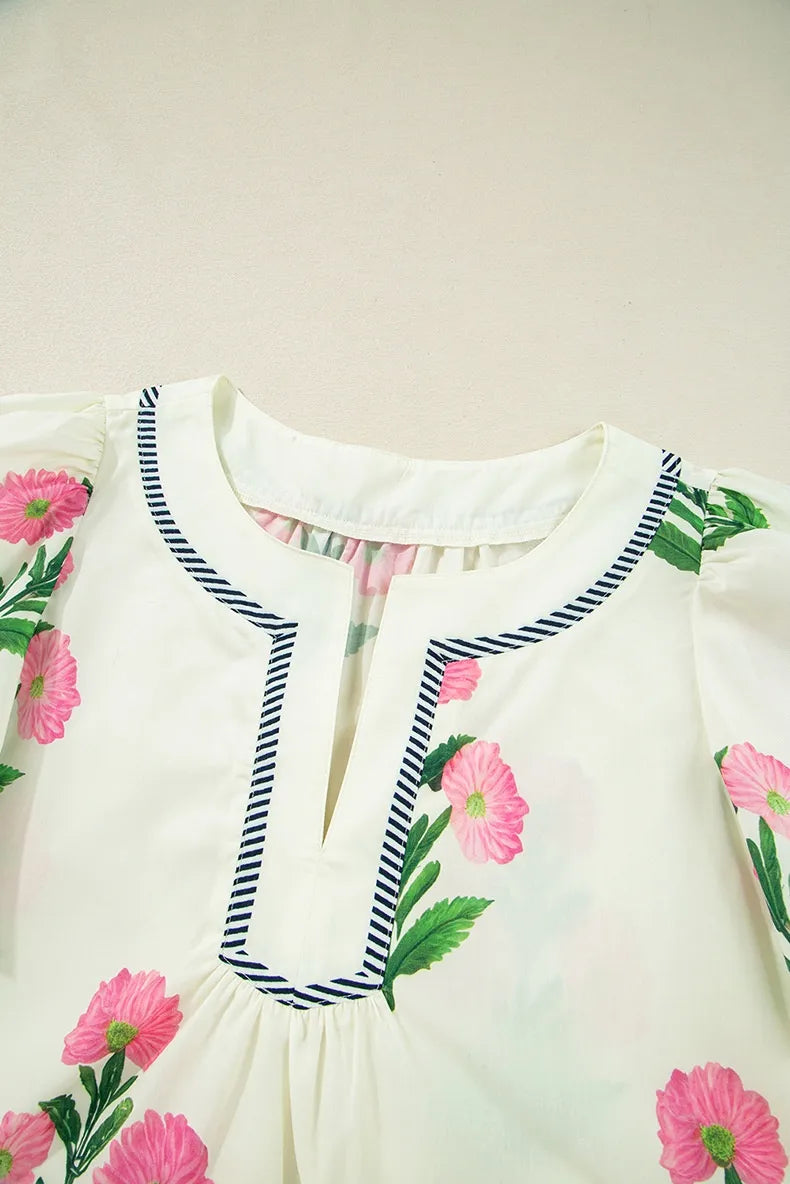 White dress with pink floral embroidery on a plain background