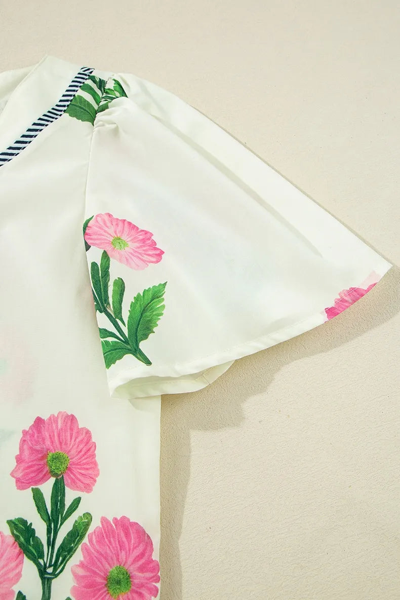 White fabric with pink floral embroidery on a beige background