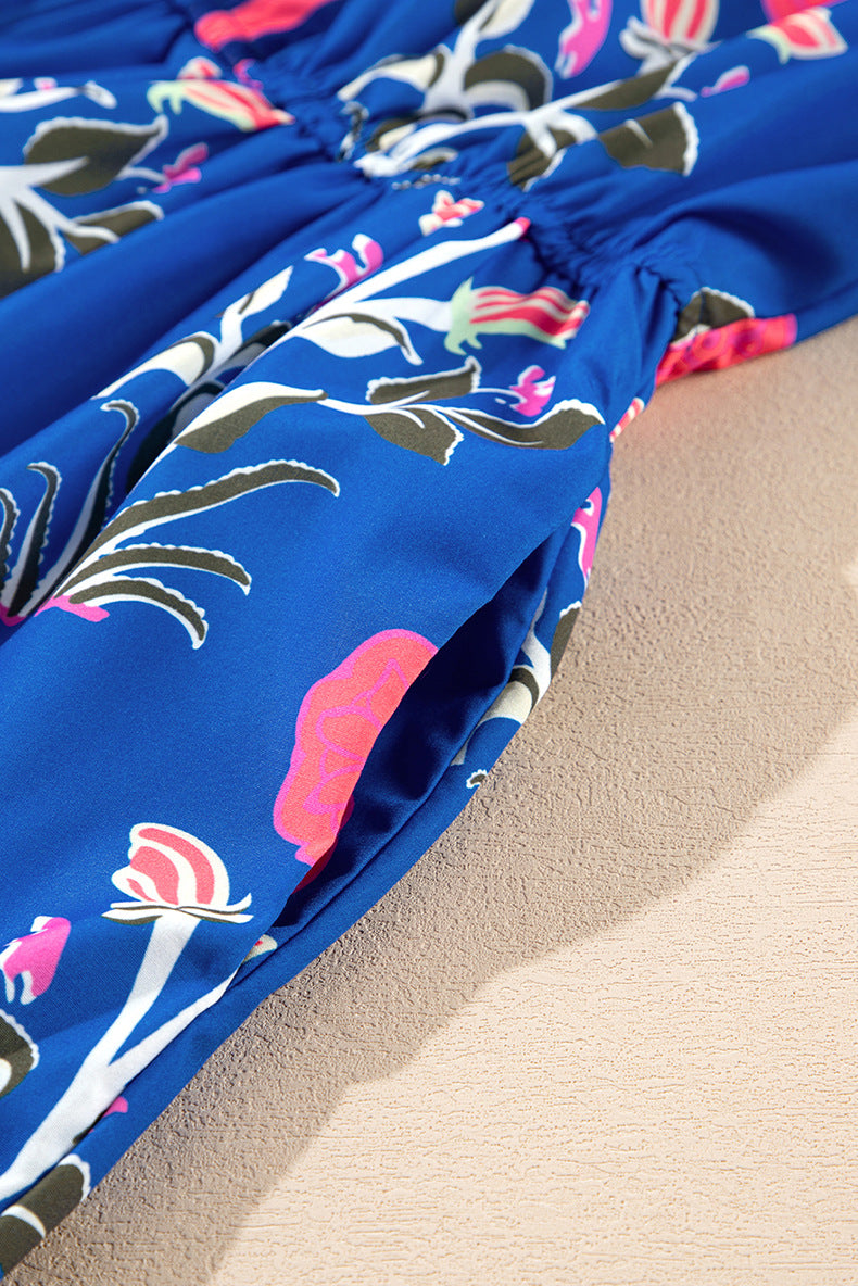 Close-up of a blue floral dress with pink flowers on a beige surface