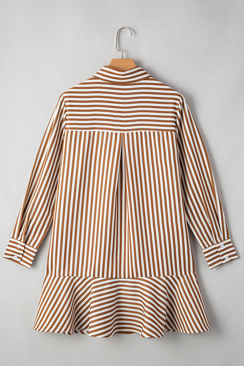 Striped dress on a hanger against a gray background