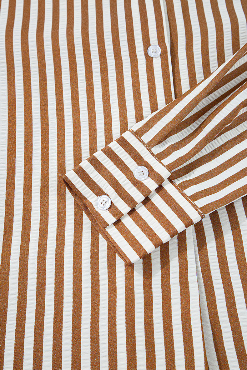 Close-up of a brown and white striped shirt with rolled-up sleeves.