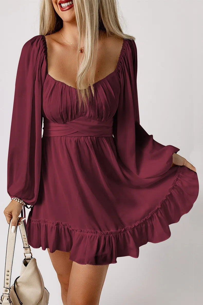 Woman wearing a burgundy dress with long sleeves on a white background