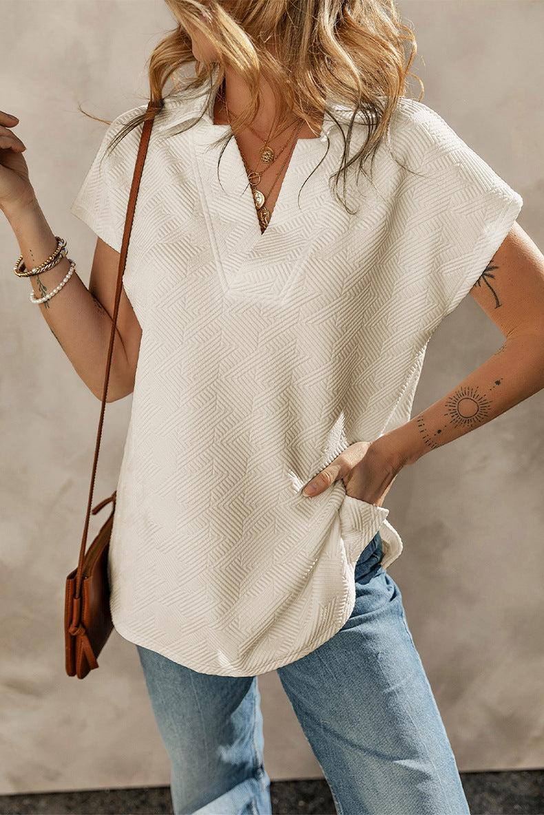 Woman wearing a white sleeveless top and blue jeans with a neutral background