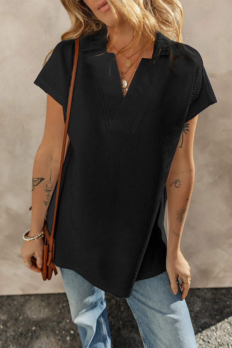 Person wearing a black top and light blue jeans with a neutral background
