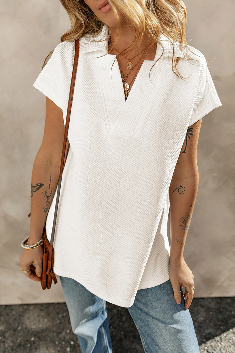 Person wearing a white short-sleeve blouse with a neutral background