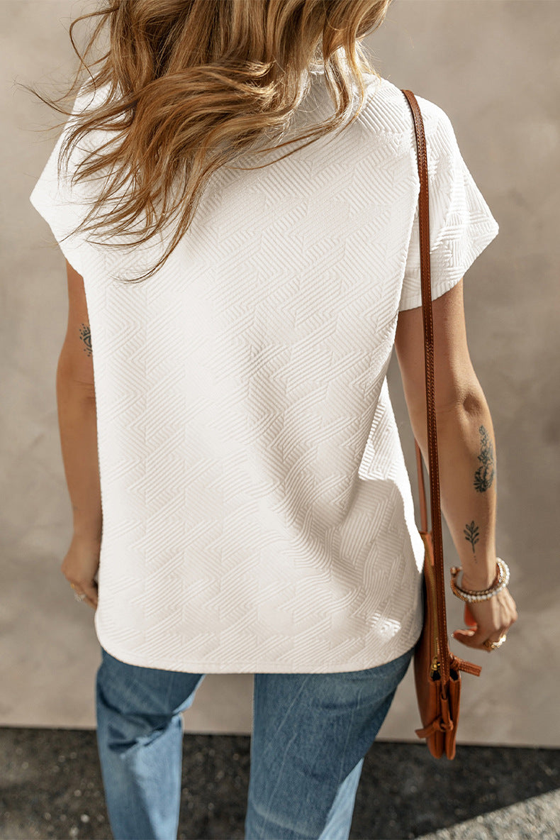 Person wearing a white sleeveless top and blue jeans, holding a brown leather bag.