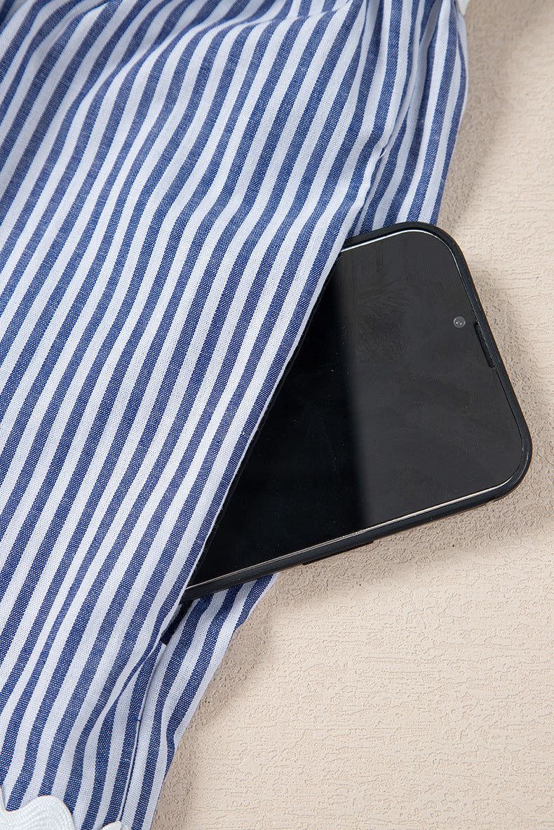 Black smartphone lying on a blue and white striped fabric