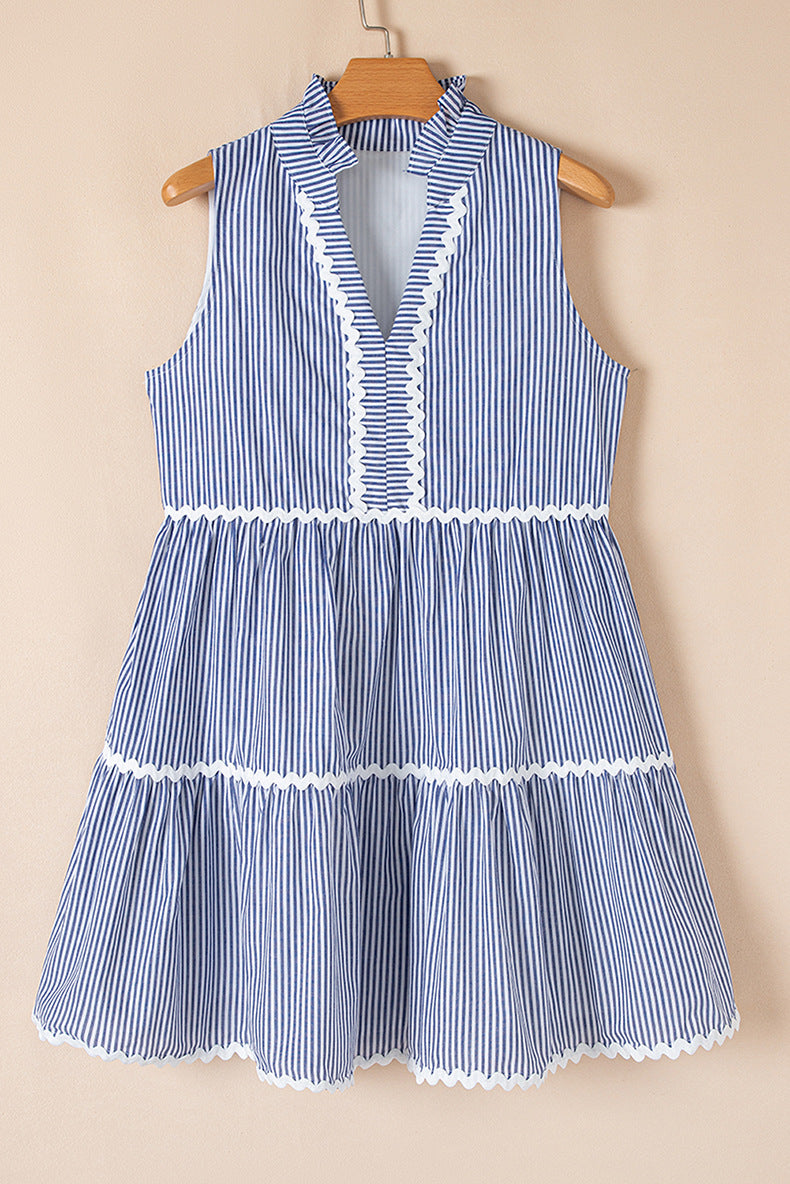 Blue and white striped dress on a wooden hanger against a beige background