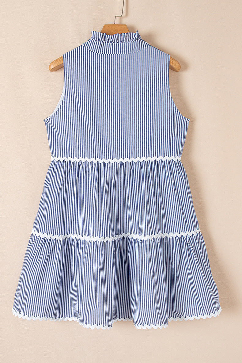 Blue and white striped dress on a wooden hanger against a beige background