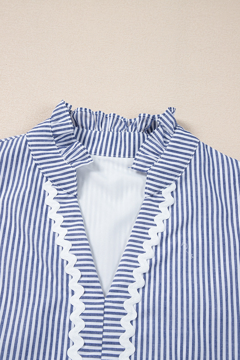 Blue and white striped shirt with ruffled trim on a beige background
